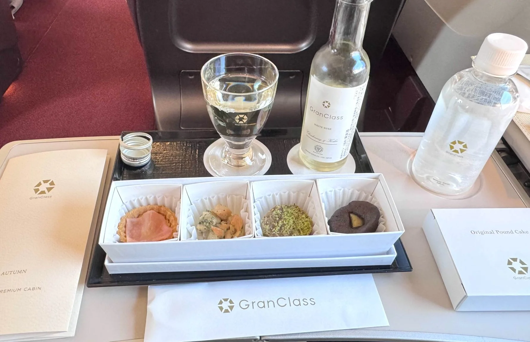 GranClass light meal and beverage service with snacks, wine, and water