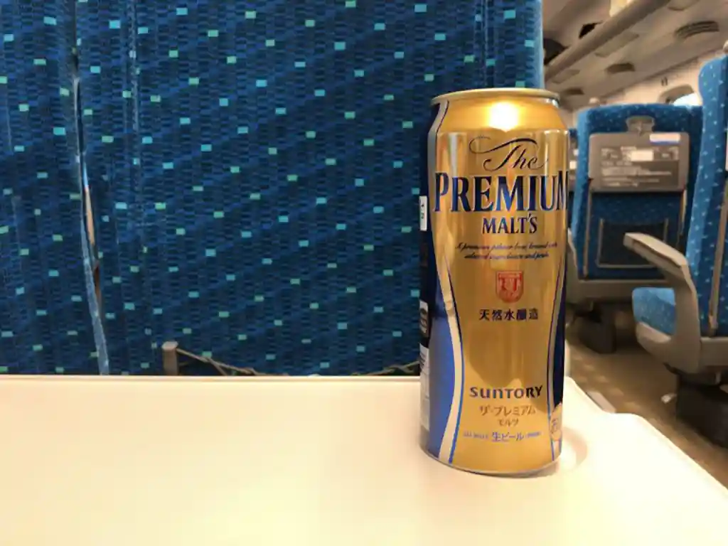 Canned beer on a tray table inside a Shinkansen car
