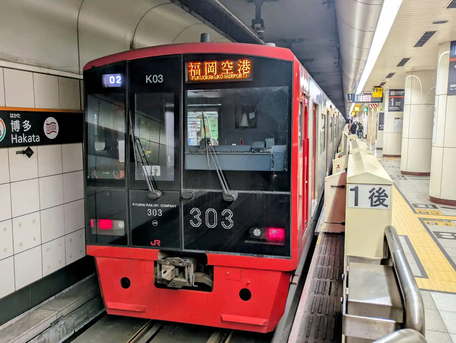 JR local train at Hakata Station platform with Fukuoka Airport shown on the destination display