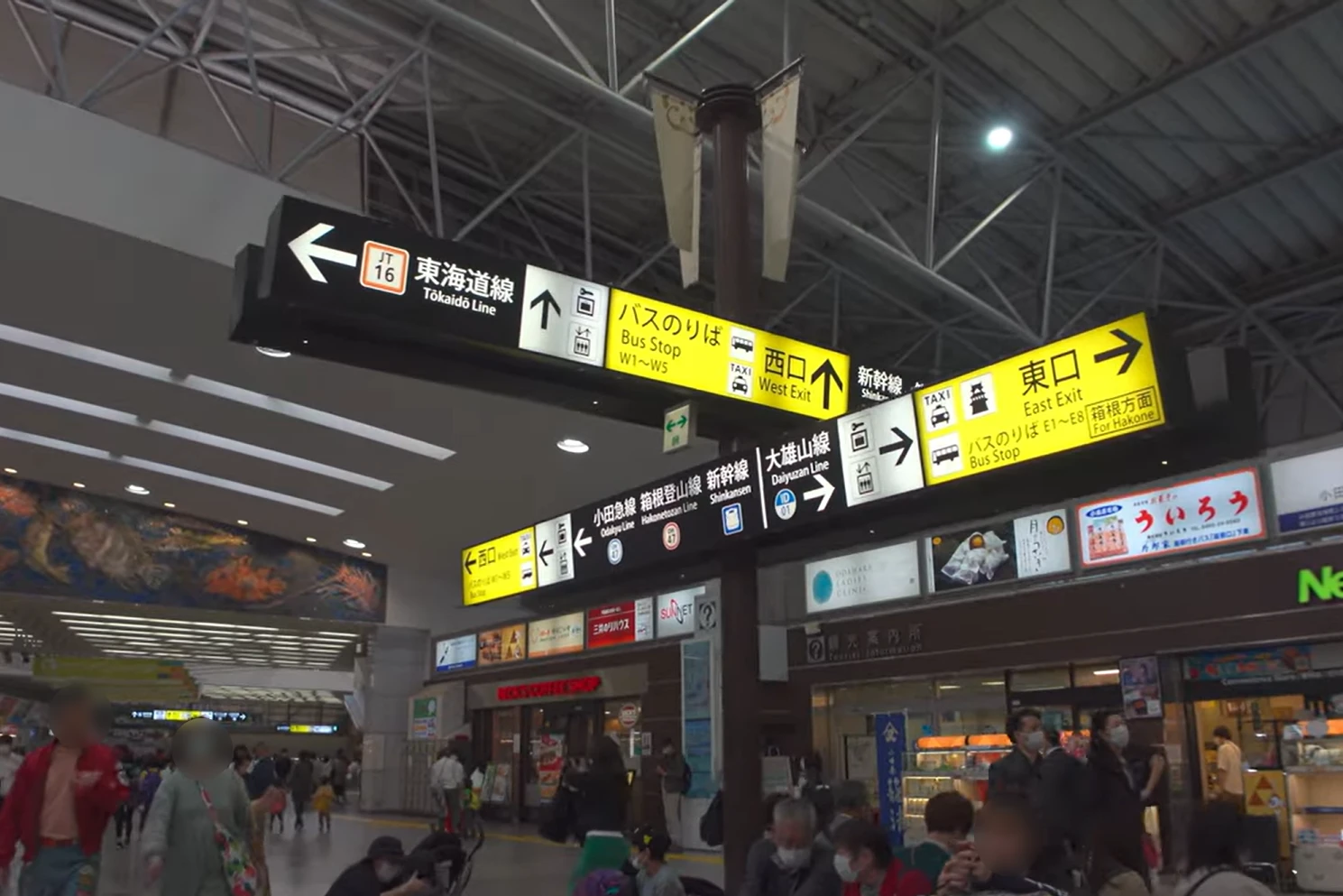 Multilingual directional signs inside Odawara Station for trains, buses, and exits