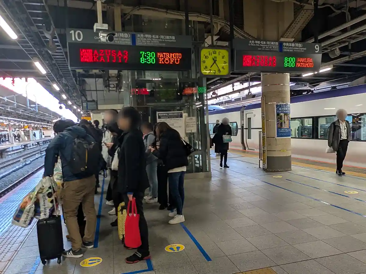Departure platform for the Fuji Excursion train at Shinjuku Station where travelers wait for trains to Kawaguchiko