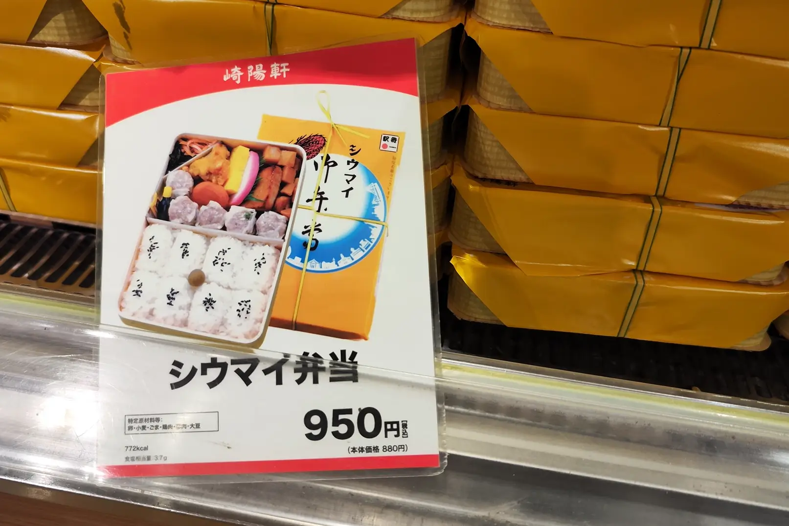 Kiyoken Shiumai boxed lunch wrapped in signature yellow box, shown stacked at station ekiben stand