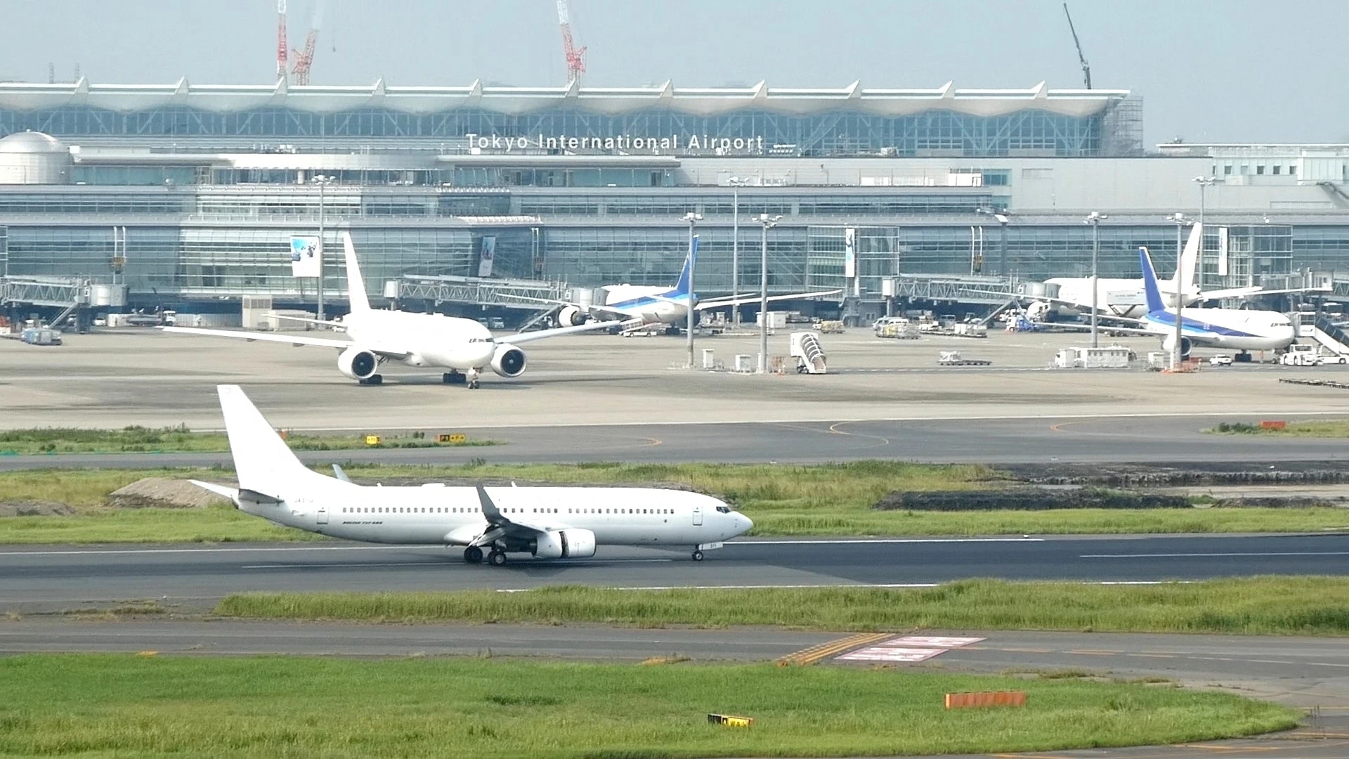 Runway and terminal view of Tokyo International Airport (Haneda) with multiple airplanes