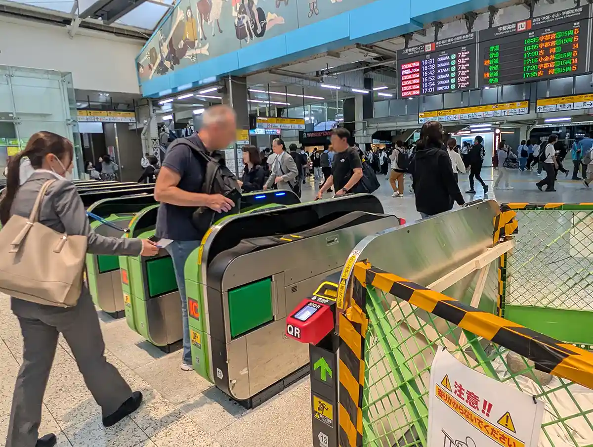 JR Ueno ticket gates with QR reader and train departure boards in the concourse
