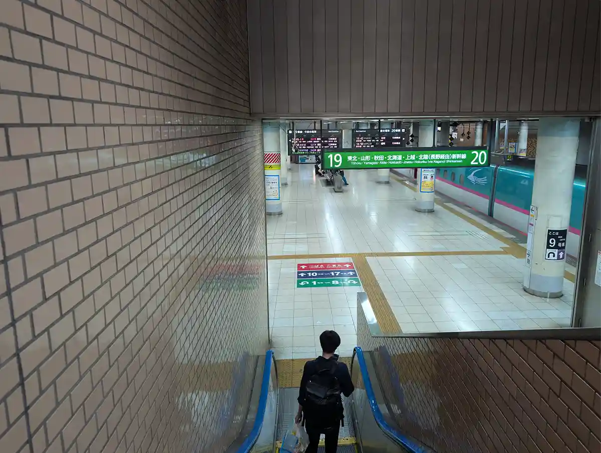 Shinkansen platform escalator at JR Ueno Station with signs for tracks 19 and 20