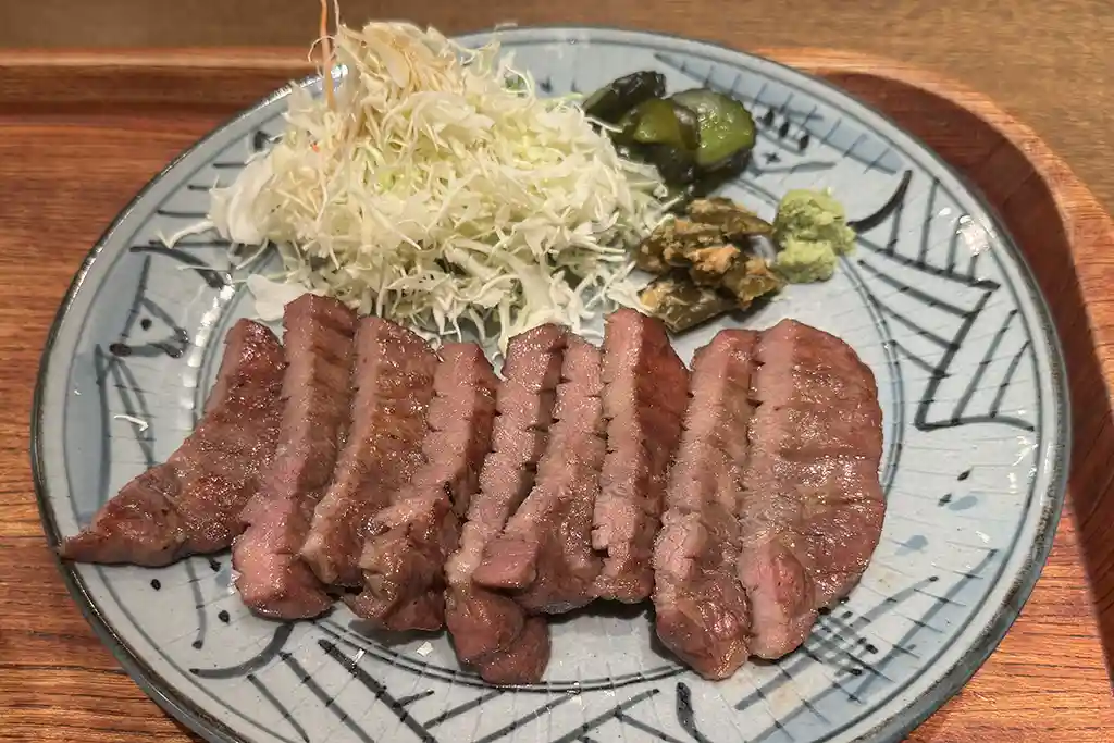 Gyutan set meal at Sendai Station featuring grilled beef tongue, cabbage, pickles, and wasabi.