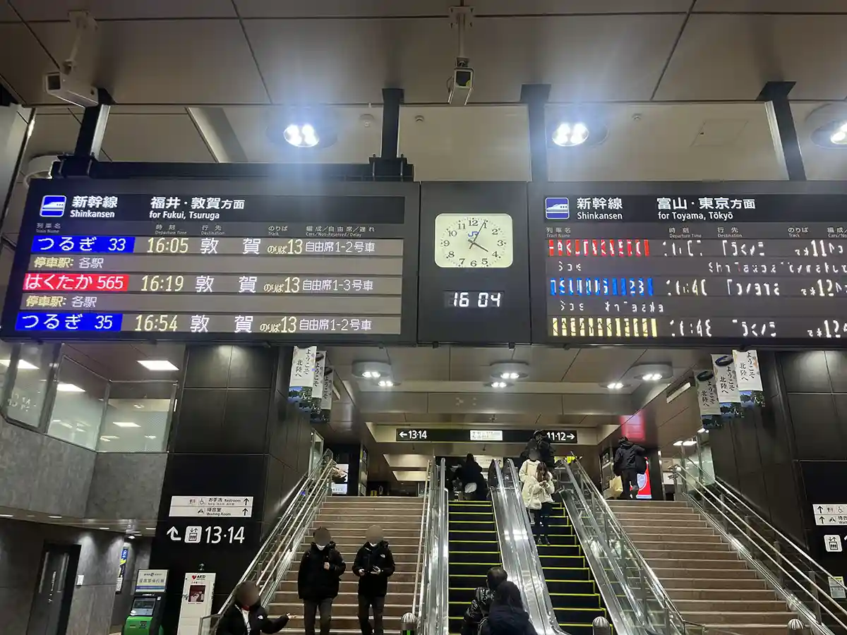 Shinkansen departure display at Kanazawa Station showing train times and destinations.