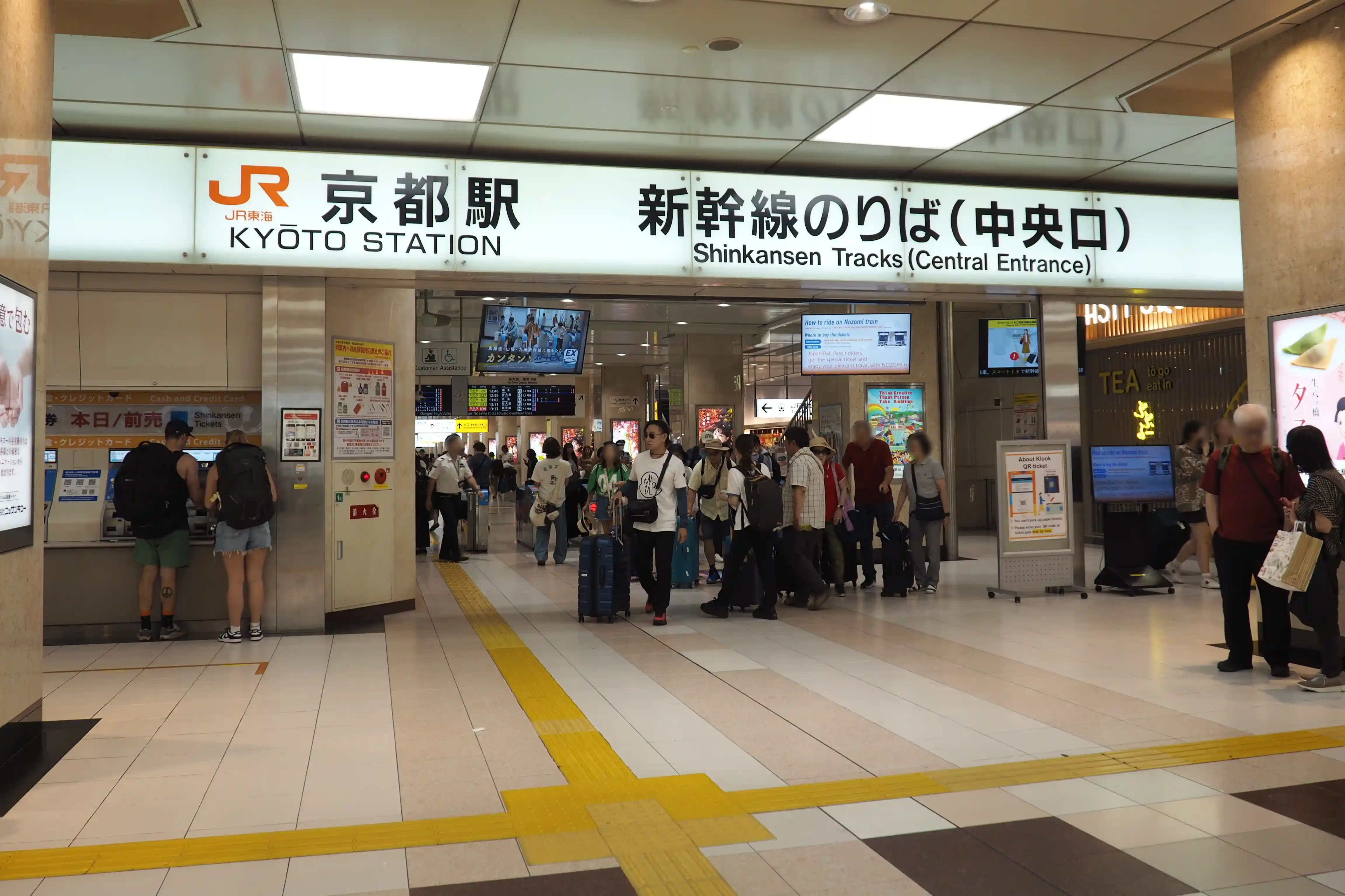 Central Gate for the Shinkansen at Kyoto Station with clear overhead signs and passengers moving toward the gates