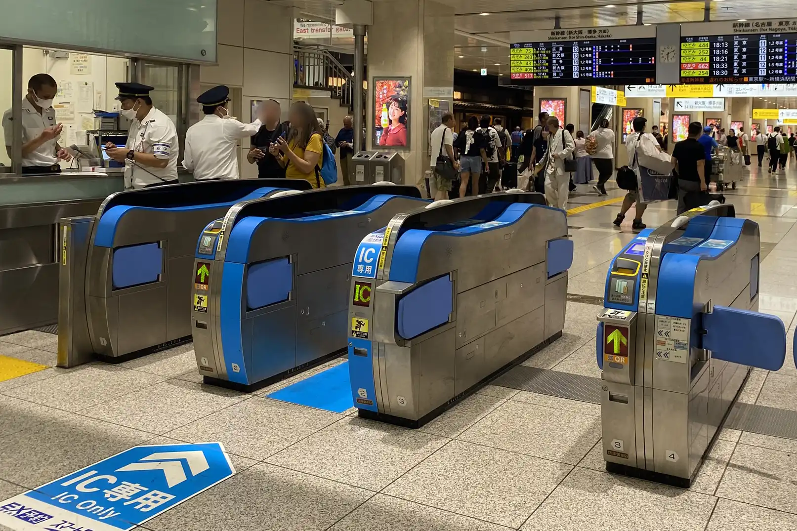 Shinkansen ticket gates at Kyoto Station with passengers and station staff assisting travelers entering the Shinkansen area