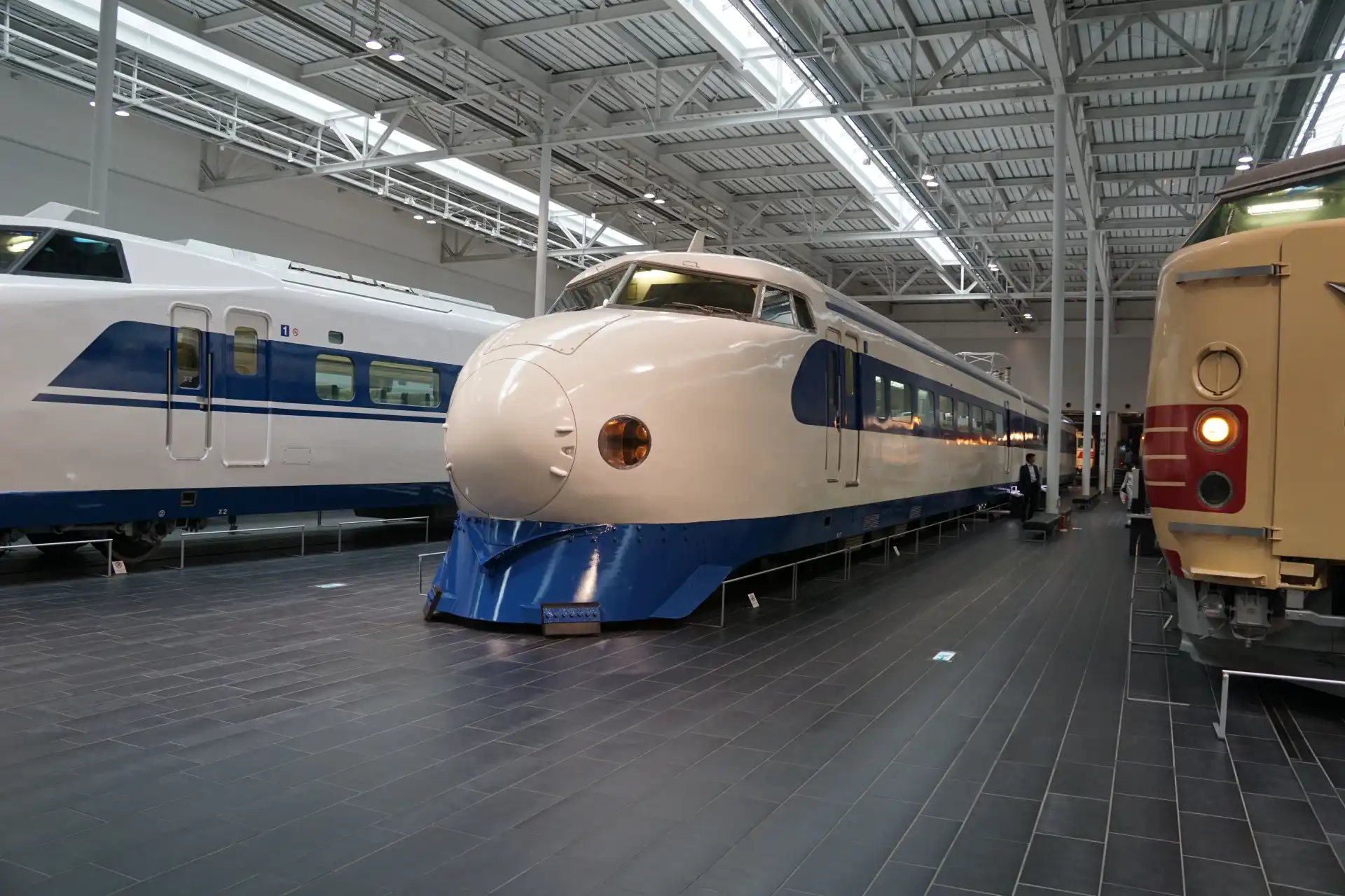 Exhibition area at SCMAGLEV and Railway Park featuring historic Shinkansen train sets arranged indoors