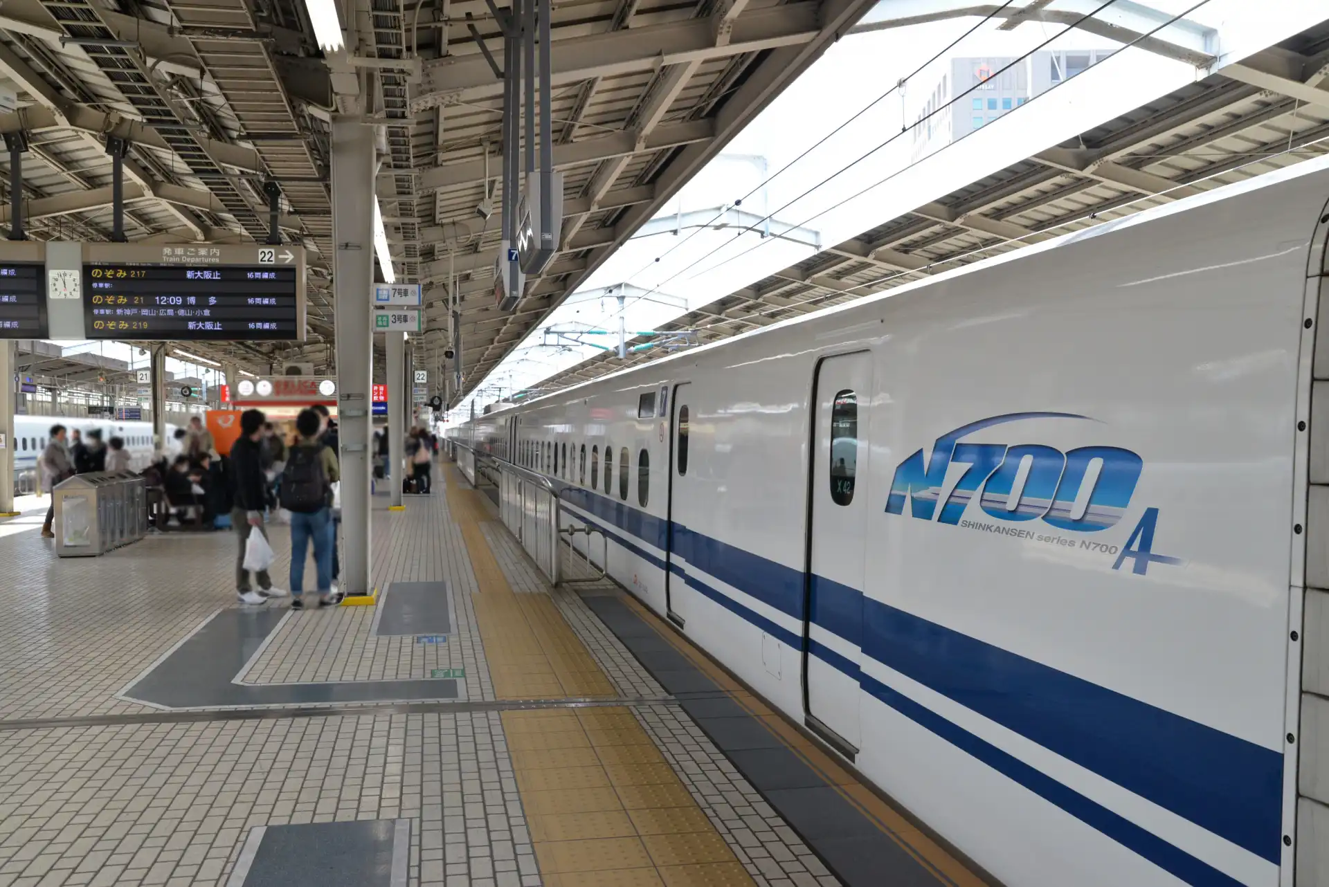 Kyoto Shinkansen platform with a long walkway, where travelers walk along the platform to reach the correct car before boarding