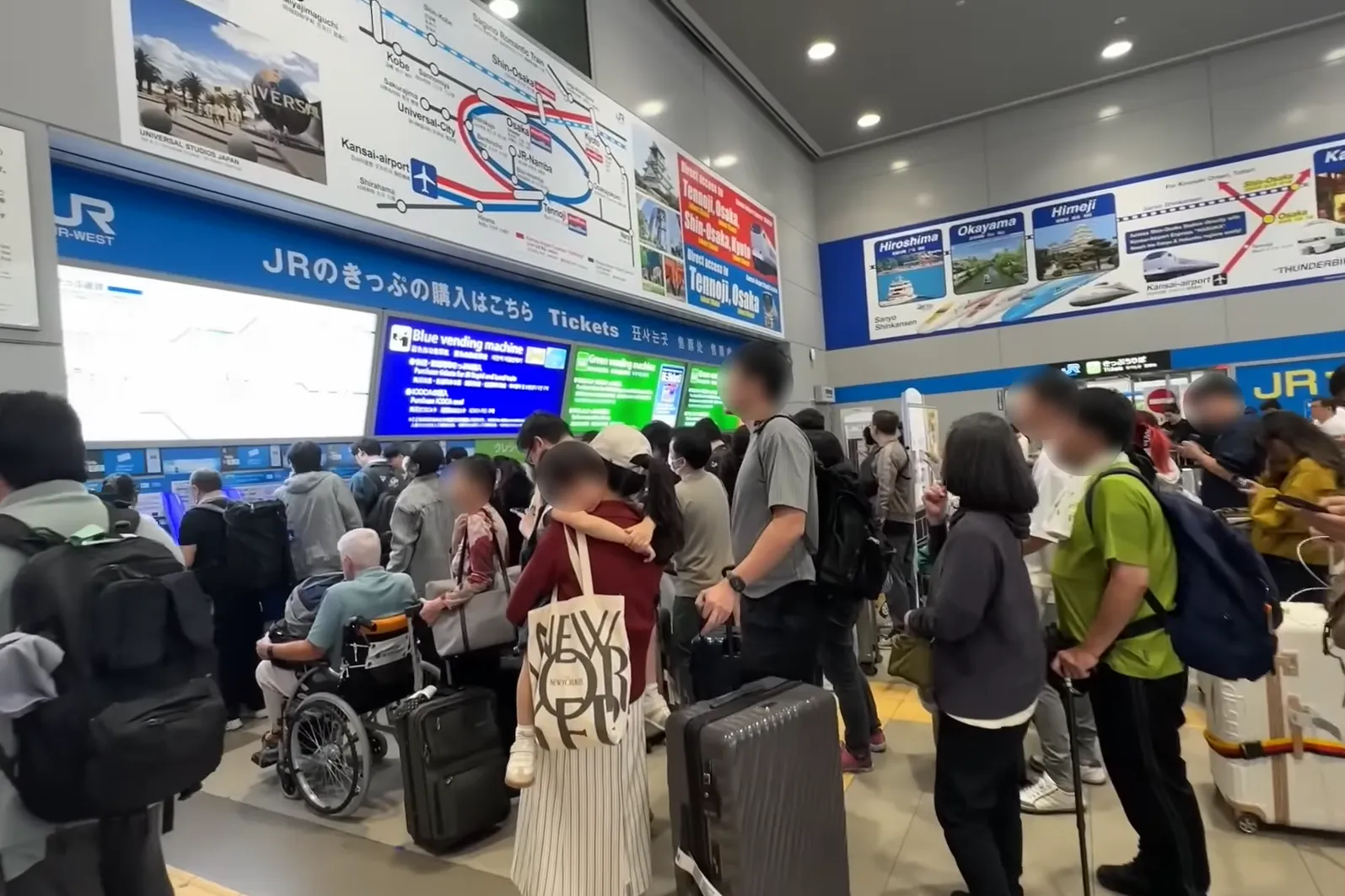 Tourists lining up at ticketing machines in Kansai Airport Station