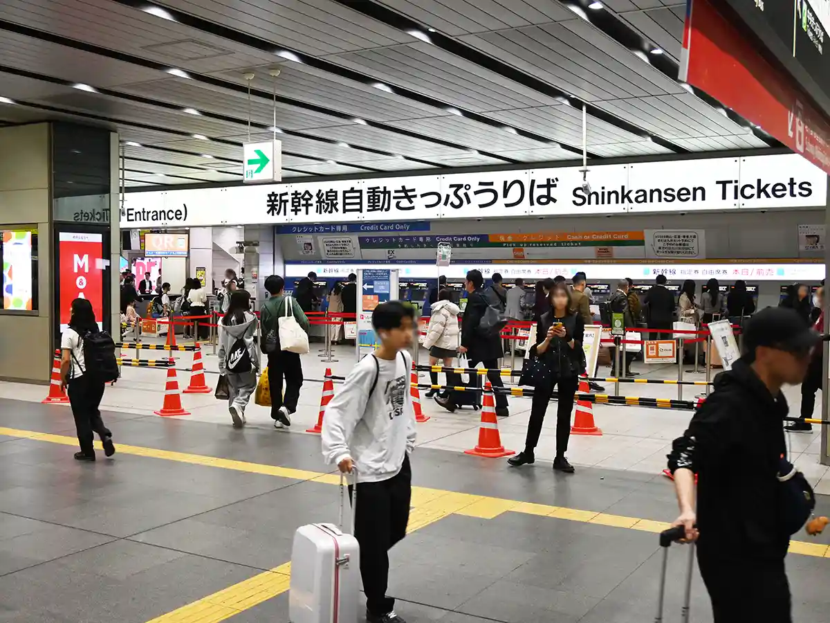 Shinkansen ticket area at Shin-Osaka Station with ticket machines after coming up from subway escalator