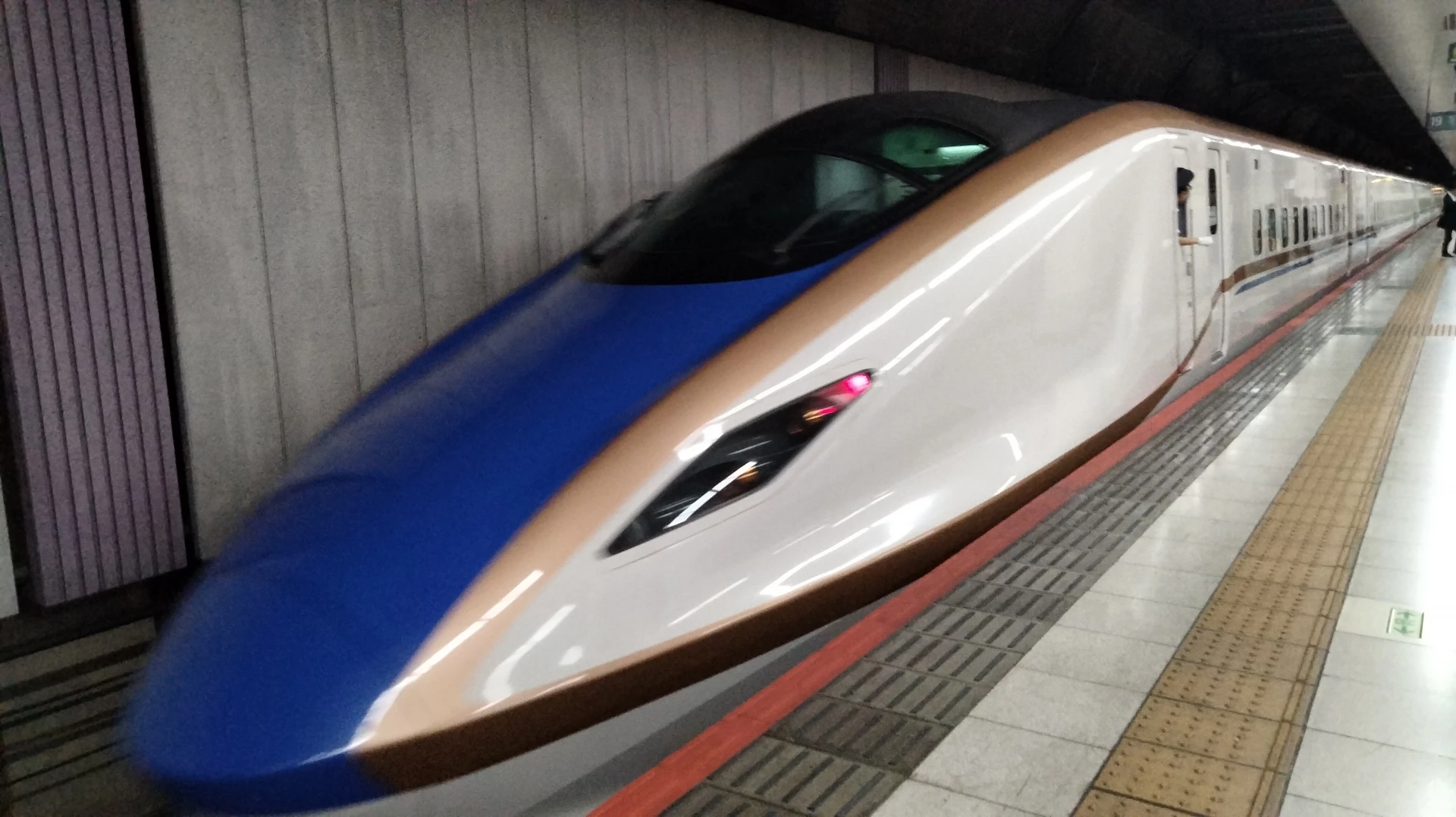 Blue and white Hokuriku Shinkansen at Ueno Station serving northern Japan routes
