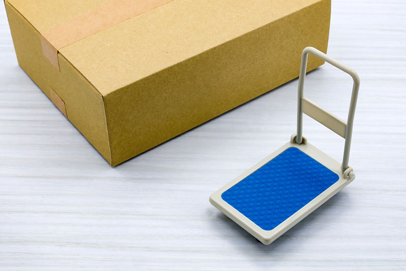 ダンボールと手前に台車のミニチュアが置かれている。