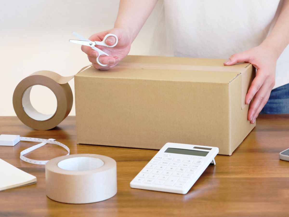 段ボールの底にガムテープを貼っている。