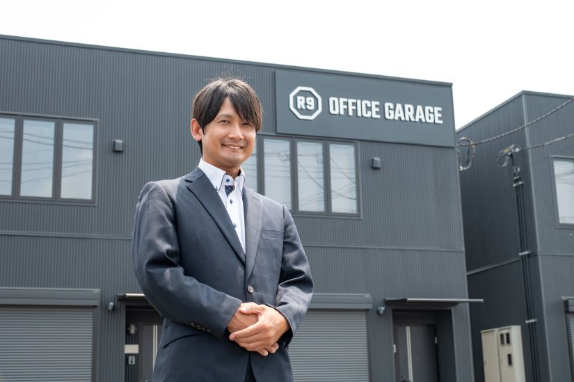 栃木市藤岡町のガレージ付きレンタルオフィス「R9 OFFICE GARAGEを背景に写る、ストレージ王の担当者。
