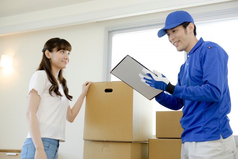 引越し業者と話をする女性の画像