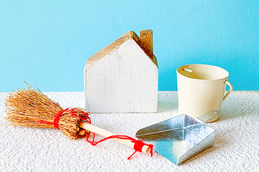 大掃除をイメージした箒やちりとり、家のミニチュアなどが置かれています