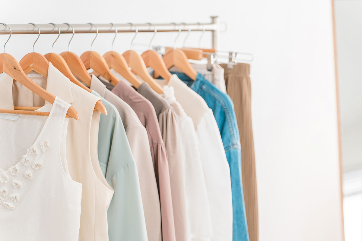ハンガーラックに10着ほど洋服がかけられている。