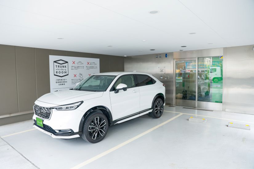 ストレージ王の屋内型トランクルームの駐車スペースの画像。屋根のついたエントランスの前に、2台分の駐車スペースが用意されている。