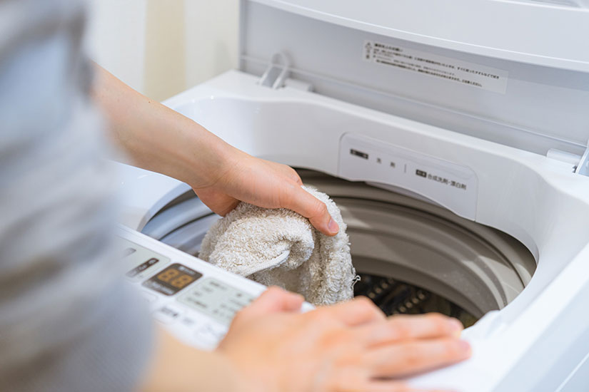 洗濯機からタオルを取り出す手元