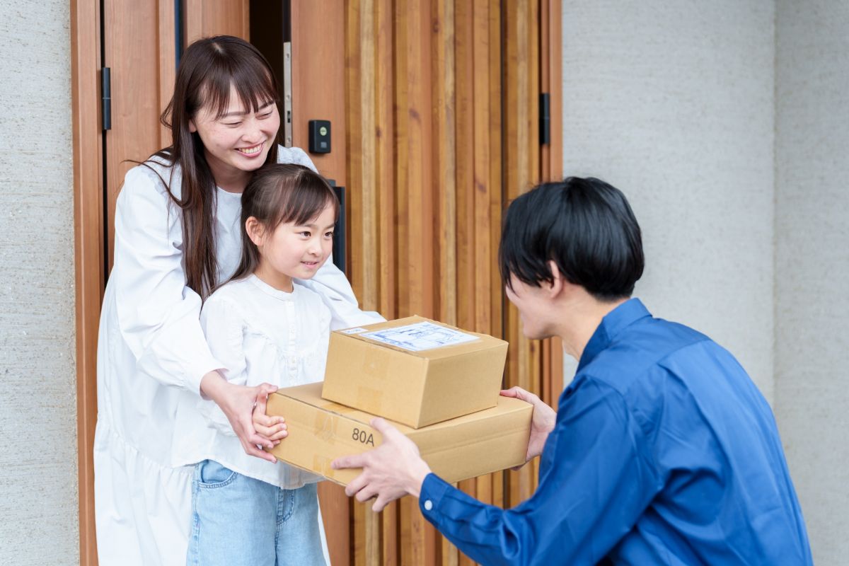 段ボールを受け取る親子。