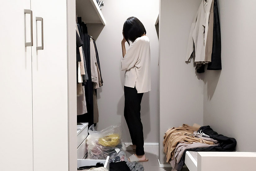 クローゼットで洋服の断捨離をする女性