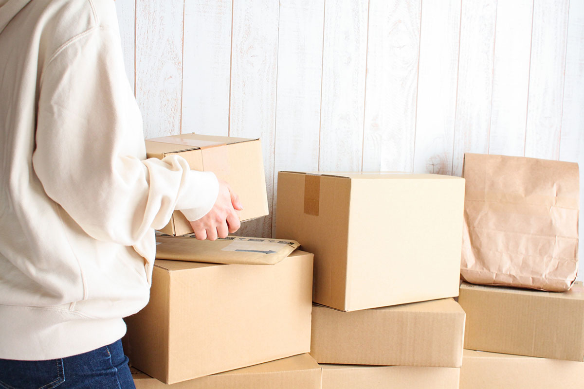 山積みの荷物と女性。