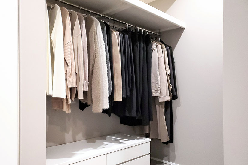 整頓されたクローゼット。上段に洋服を掛け、下段にタンスを置いた収納例。