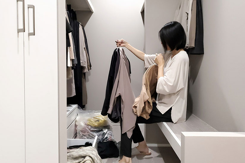 クローゼットで洋服の断捨離をしている女性