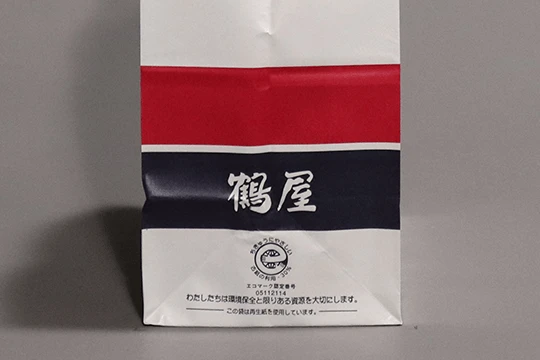 鶴屋, 一般用 マチには漢字のロゴタイプ。開店時に書家の斉藤鶴跡氏によって書かれたもの。