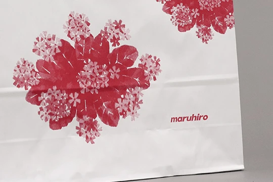 丸広百貨店, 一般用 右下にロゴタイプ サクラソウのイラストレーションはほどよい粒度で描かれている