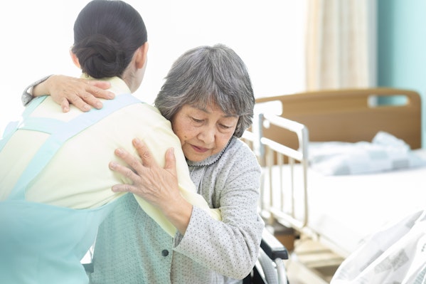 起き上がりの介助をうける高齢者