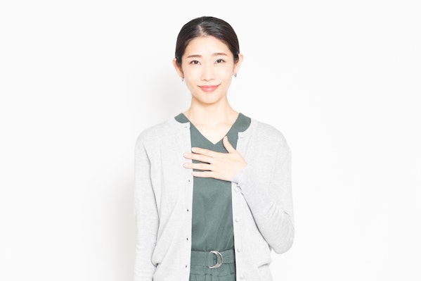 胸に手を当てる女性