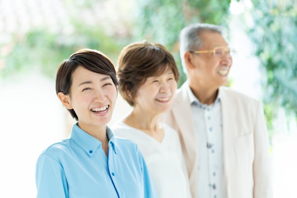 笑顔の介護士と高齢者夫婦