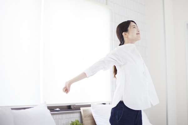 身体を伸ばす白い服を着た女性