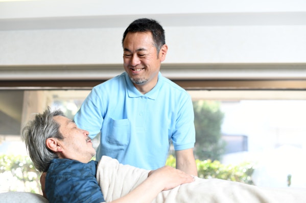 ベッドへ移動の介助をする男性