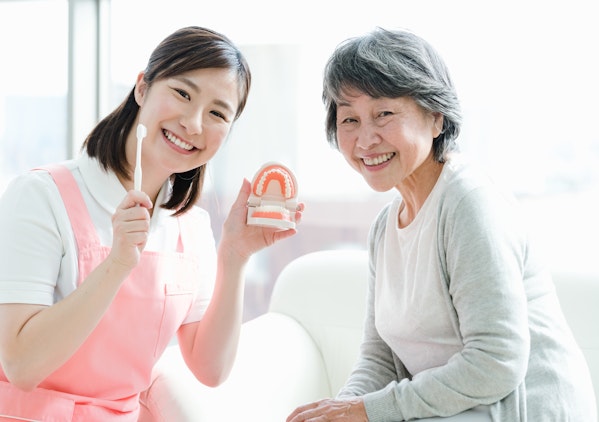 口腔ケアを行う介護士と女性