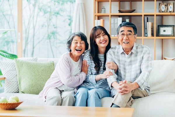 自宅で笑顔で寄り添う3人家族