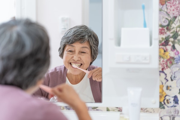 鏡を見ながら歯を磨く高齢者