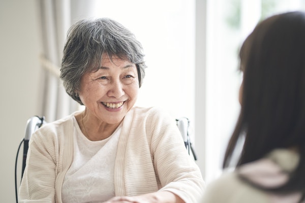 車いすに乗る笑顔の高齢者女性