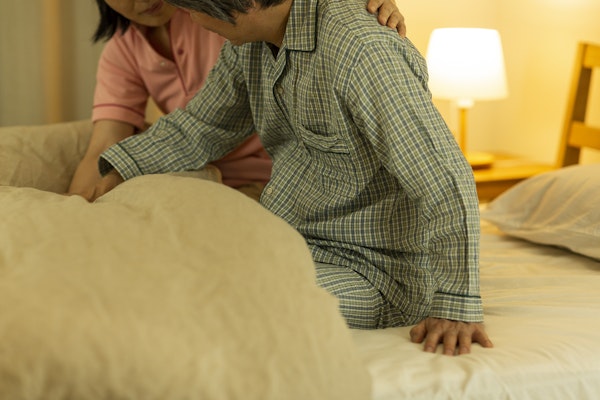 起き上がりの介助をする女性