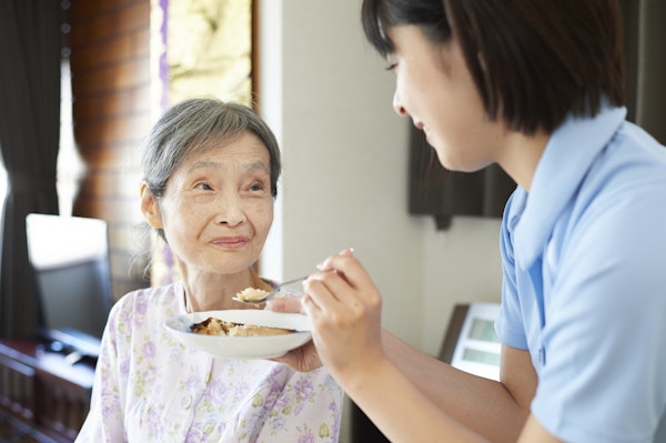 食事の介助をうける高齢者