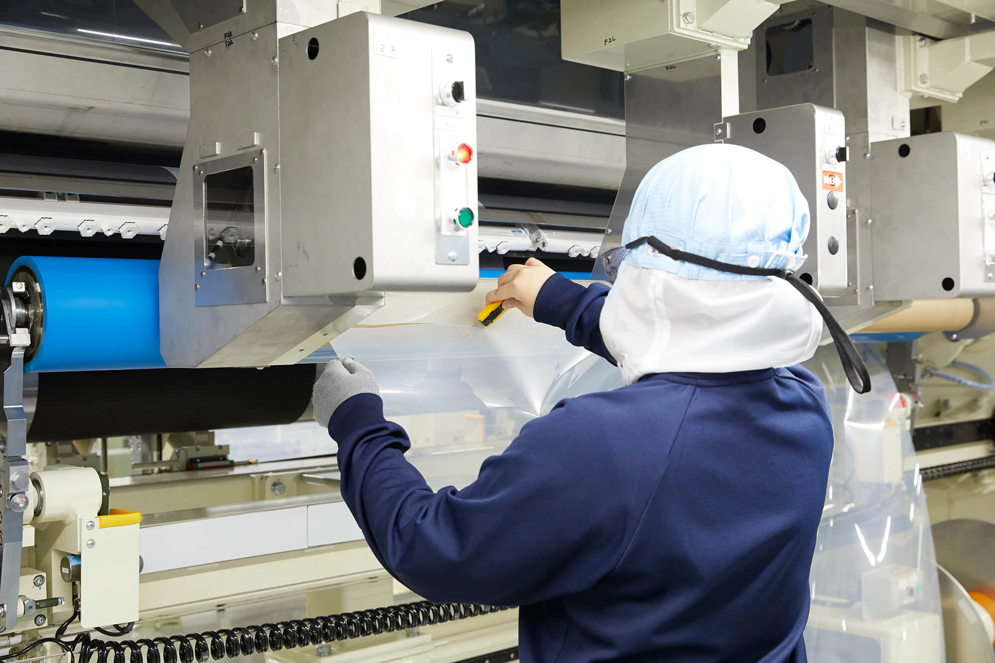 フィルムをカットする根本さん