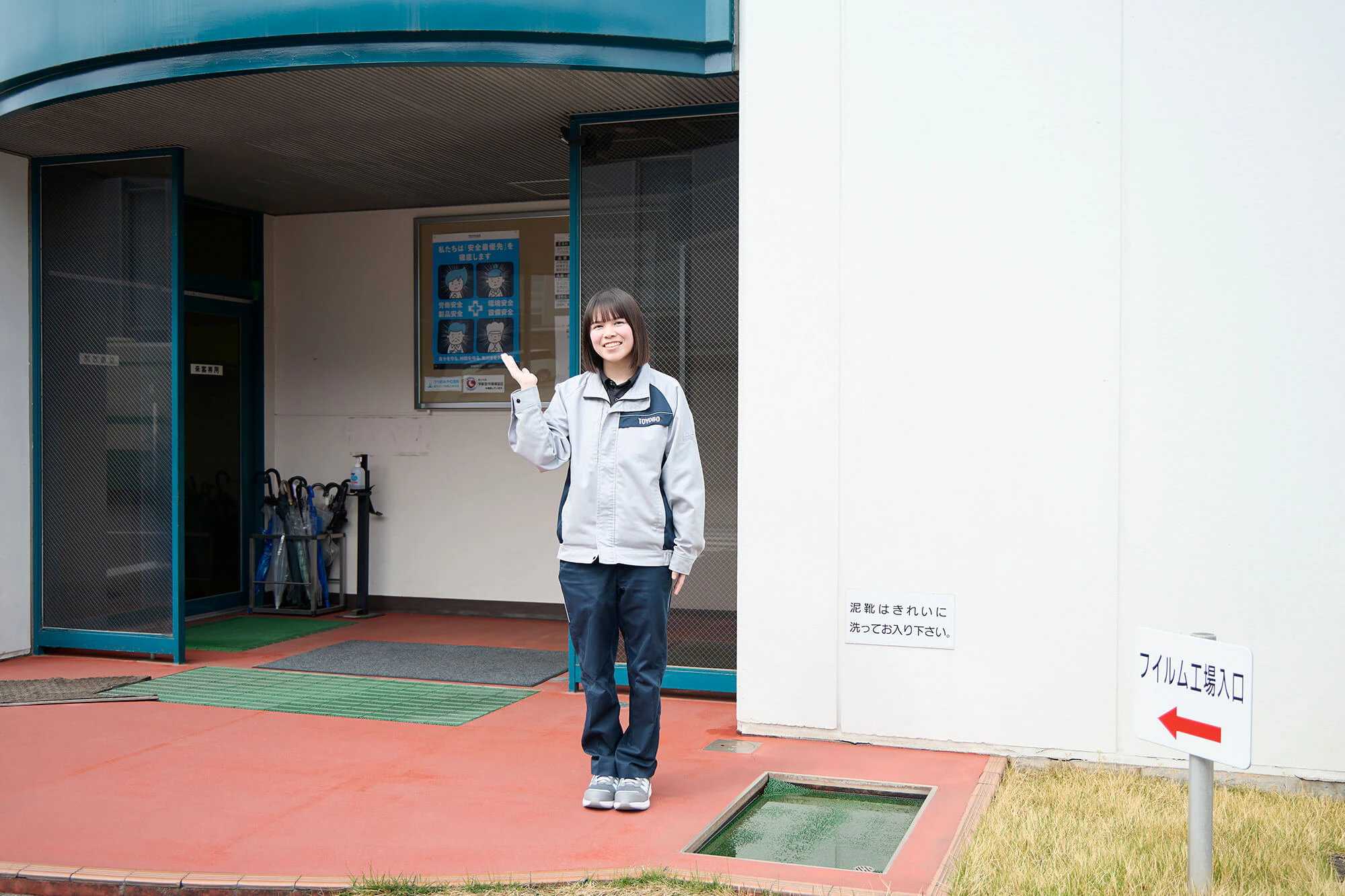 フィルム工場入り口に立つ高木さん