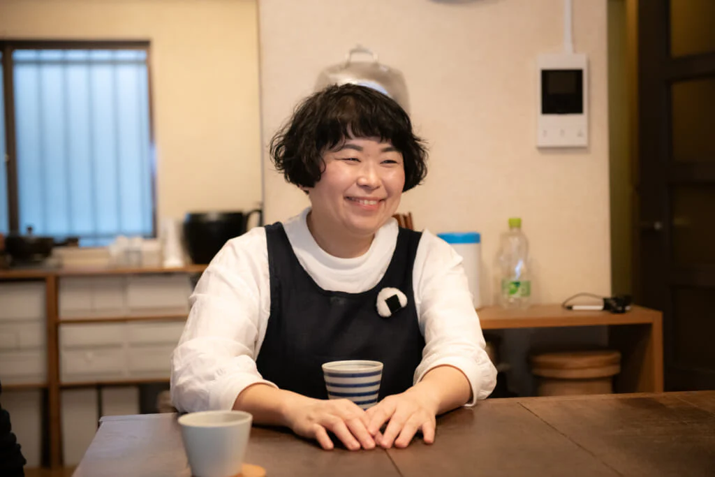 おにぎりが大好きなのりこさんの胸には、おにぎりのブローチが。