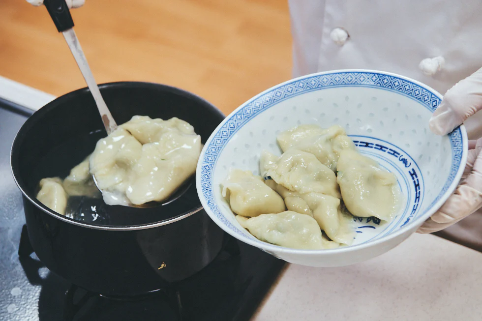 茹で上がった水餃子を器に盛る