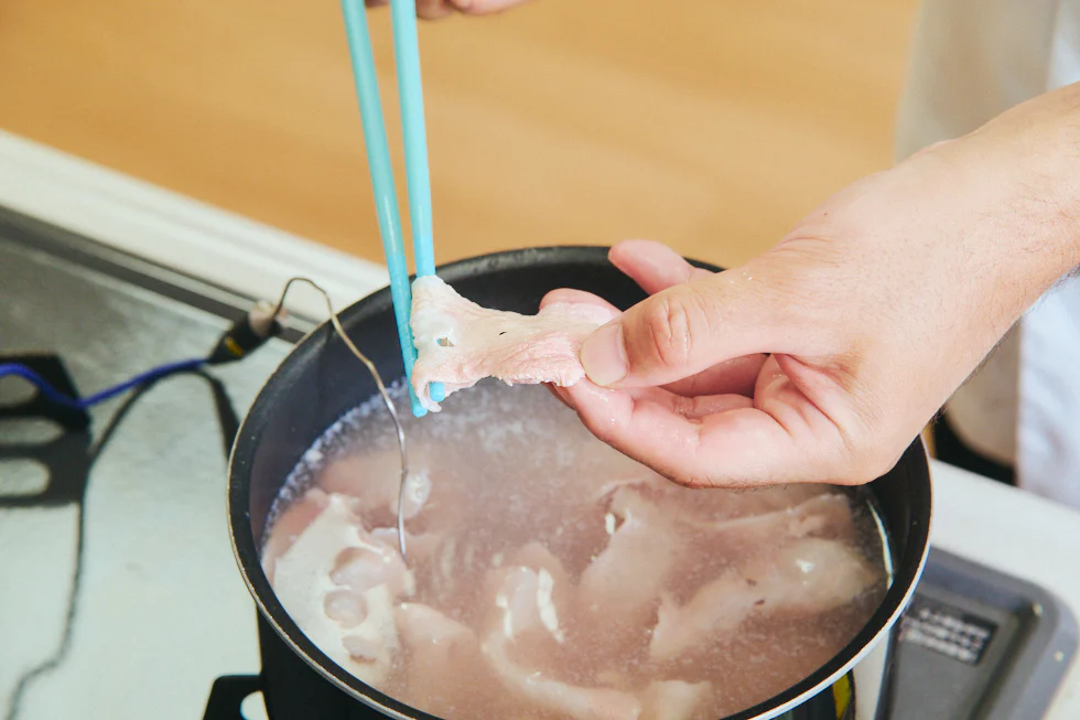 肉の茹で具合を確認する様子