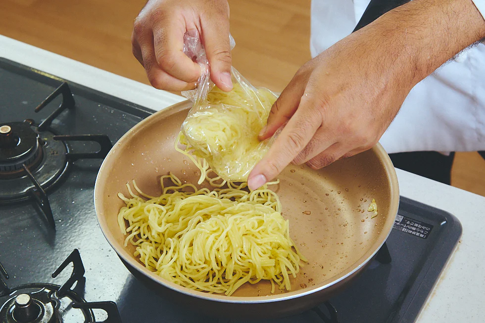 フライパンに麺を入れる様子